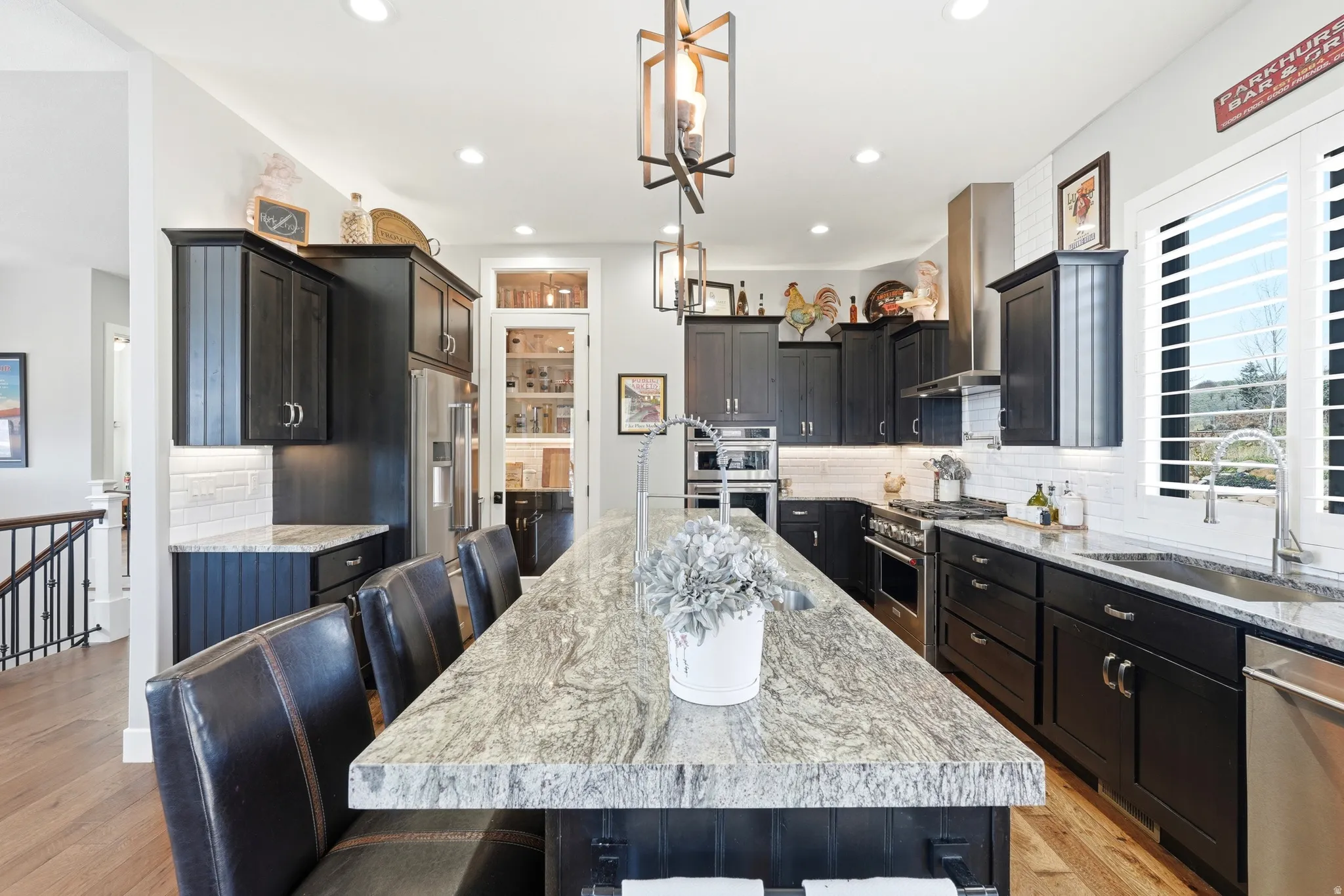 Kitchen with a kitchen bar, tasteful backsplash, light stone countertops, and premium appliances