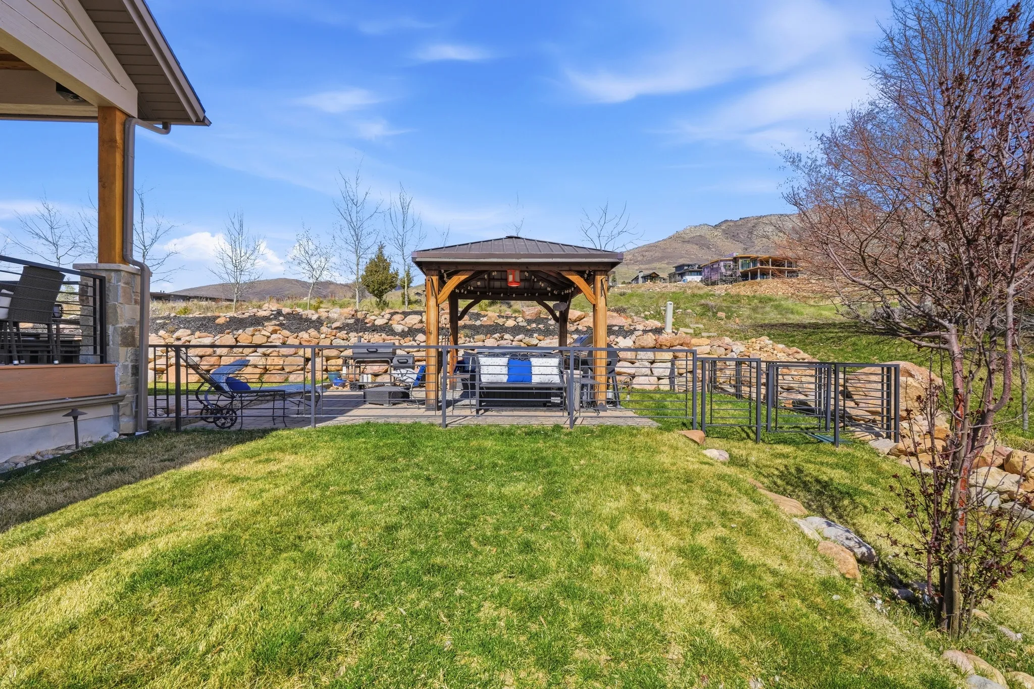 View of green lawn featuring a gazebo, a mountain view, and a patio