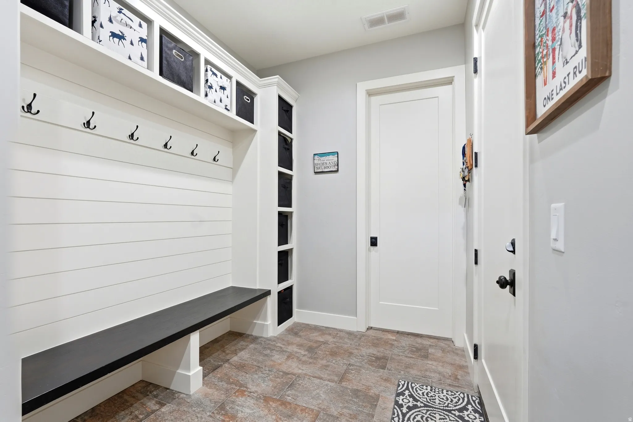 Mudroom featuring stone finish floors and baseboards