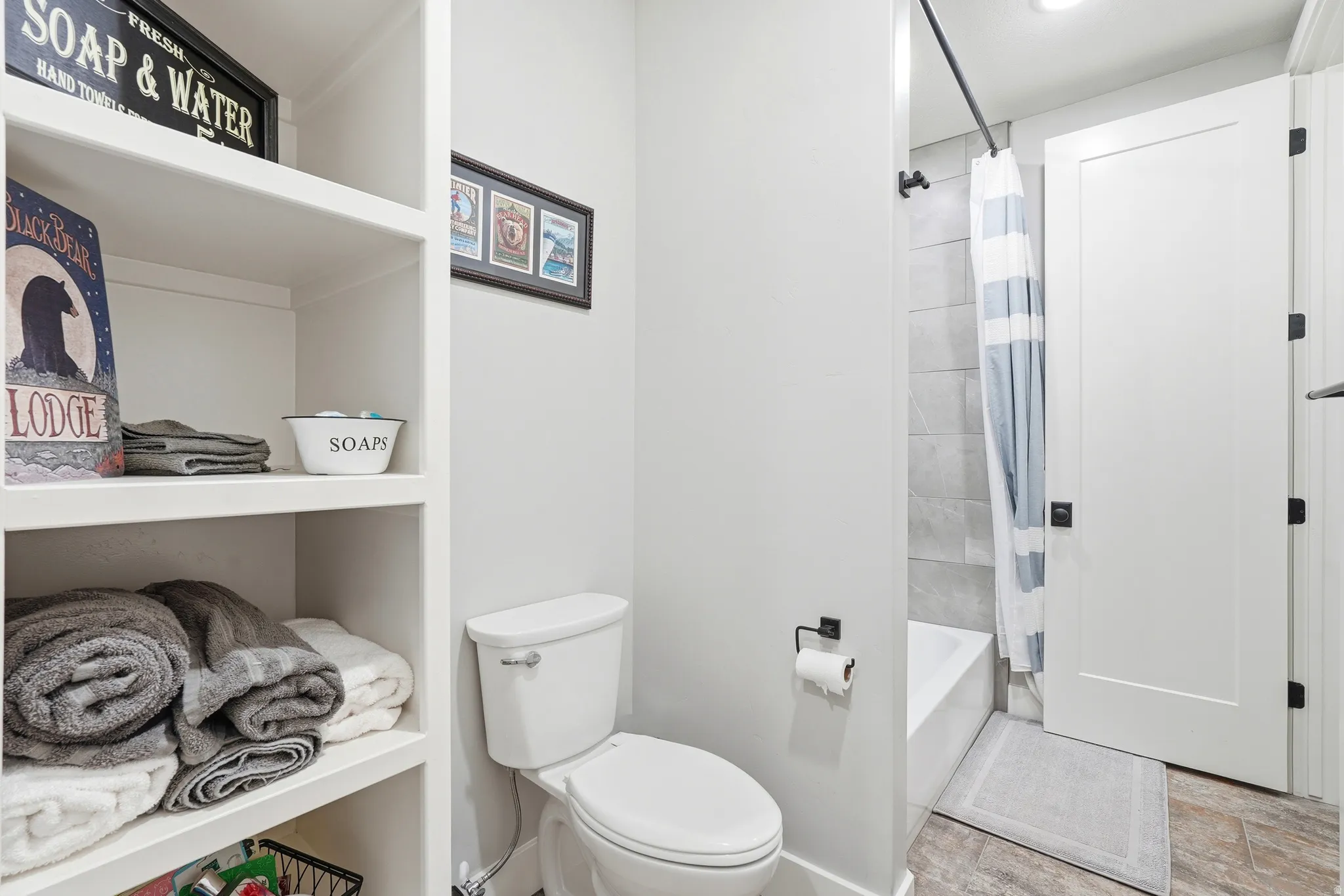 Full bathroom featuring toilet and shower / bathtub combination with curtain