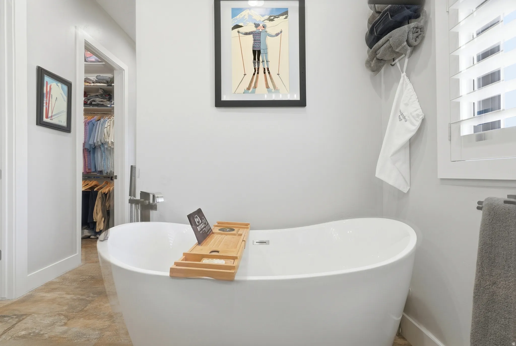Bathroom with a soaking tub and a walk in closet