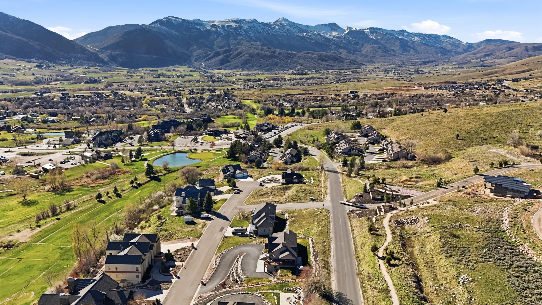 Aerial view of property and surrounding area featuring a water and mountain view and nearby suburban area