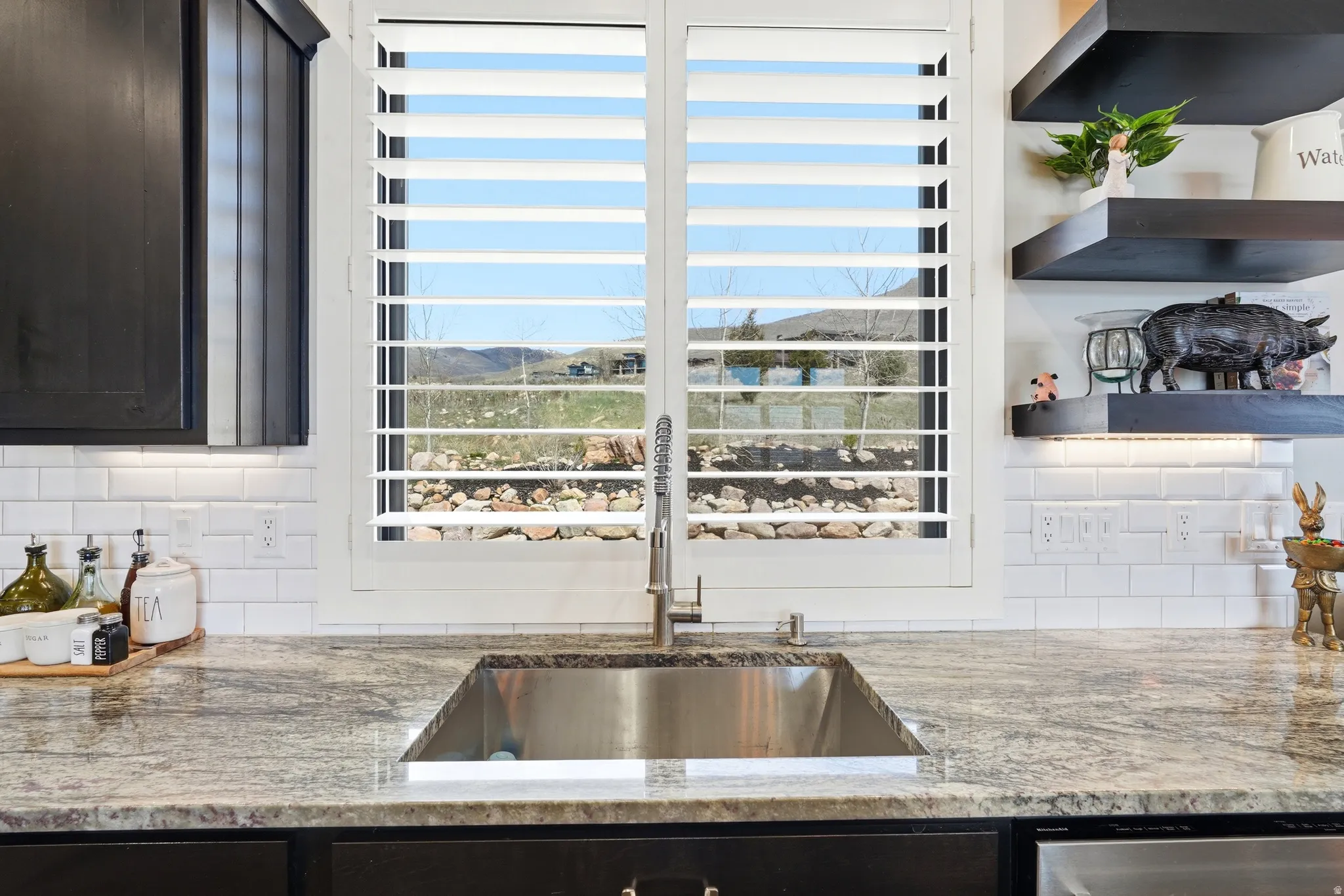 Kitchen featuring light stone countertops, tasteful backsplash, a mountain view, and open shelves