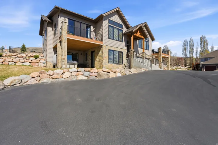 View of front of home featuring a patio and stone siding
