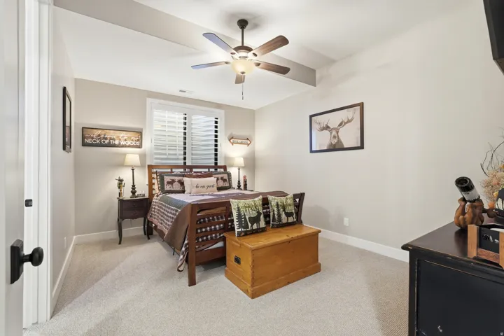 Bedroom with light colored carpet and a ceiling fan