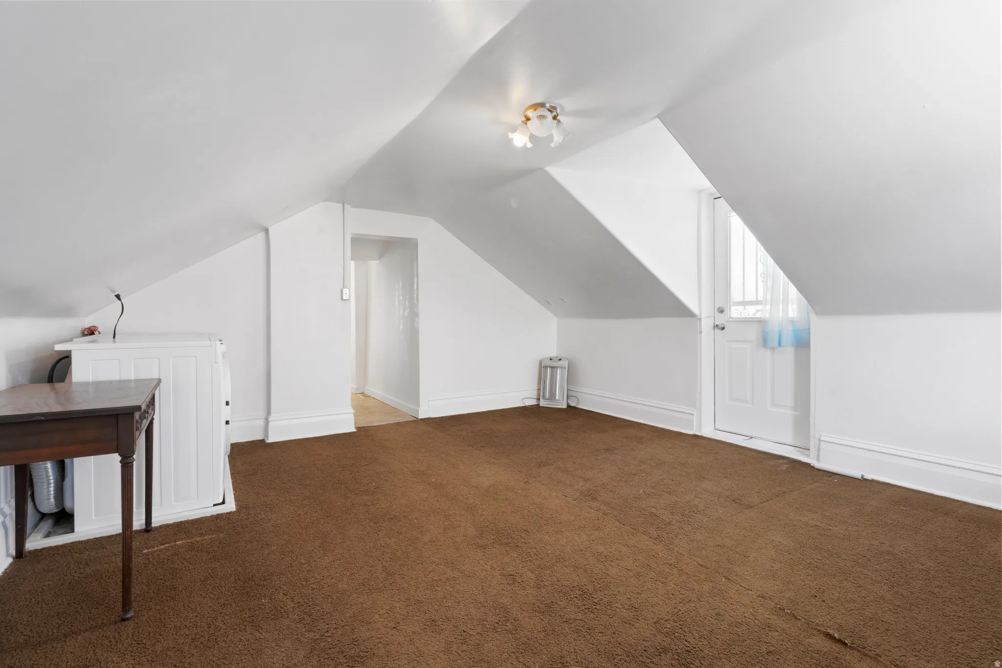 Bonus room featuring dark carpet and independent washer and dryer