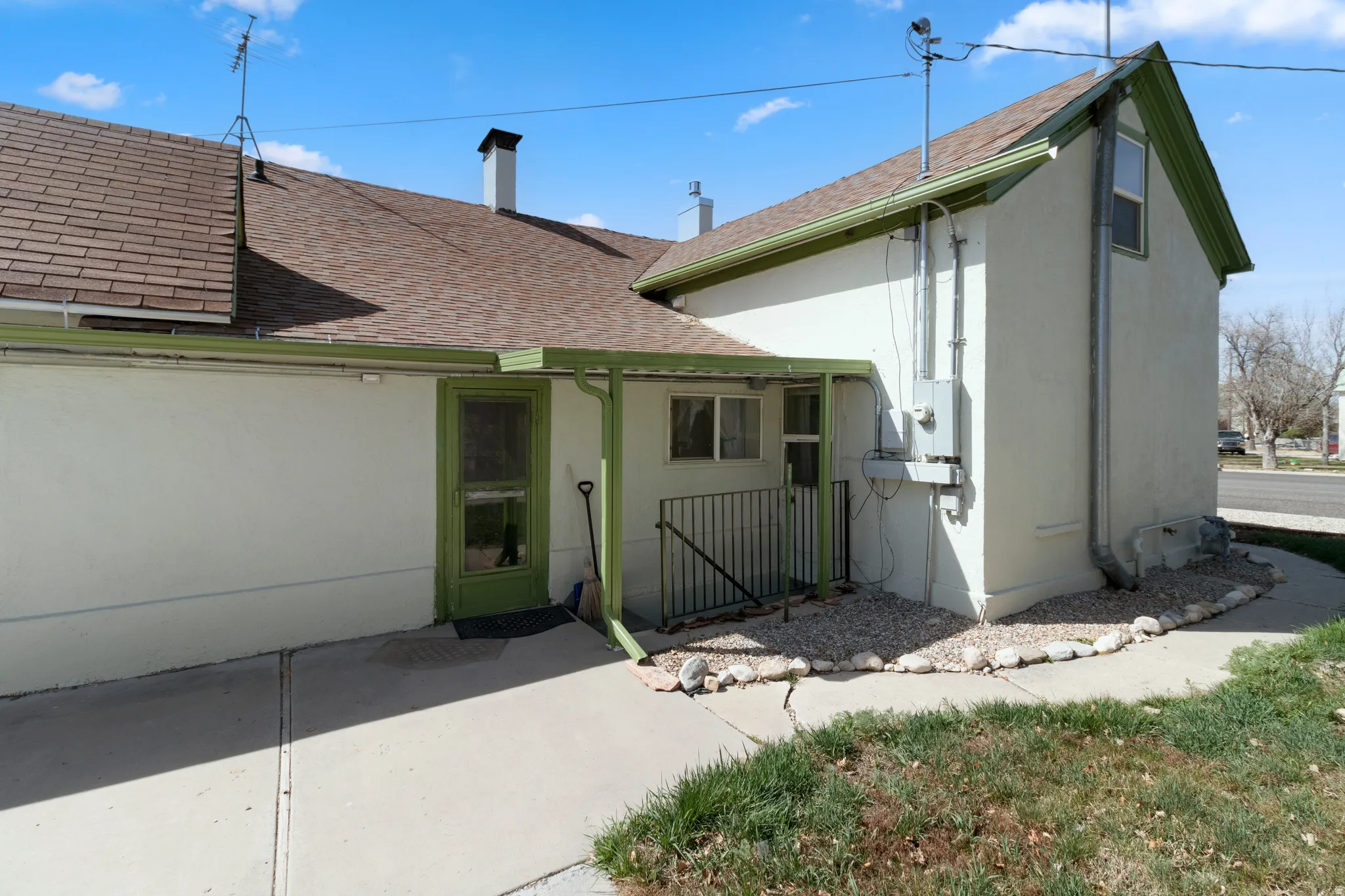 Back of property with roof with shingles and stucco siding