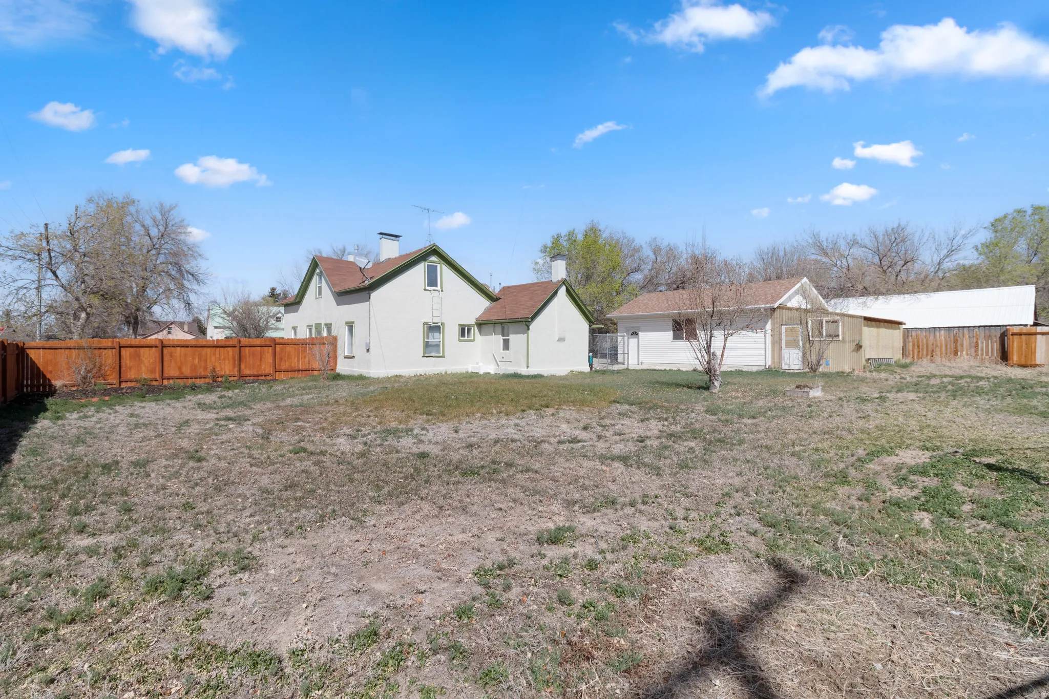 Rear view of property with a fenced backyard, an outbuilding, and a residential view