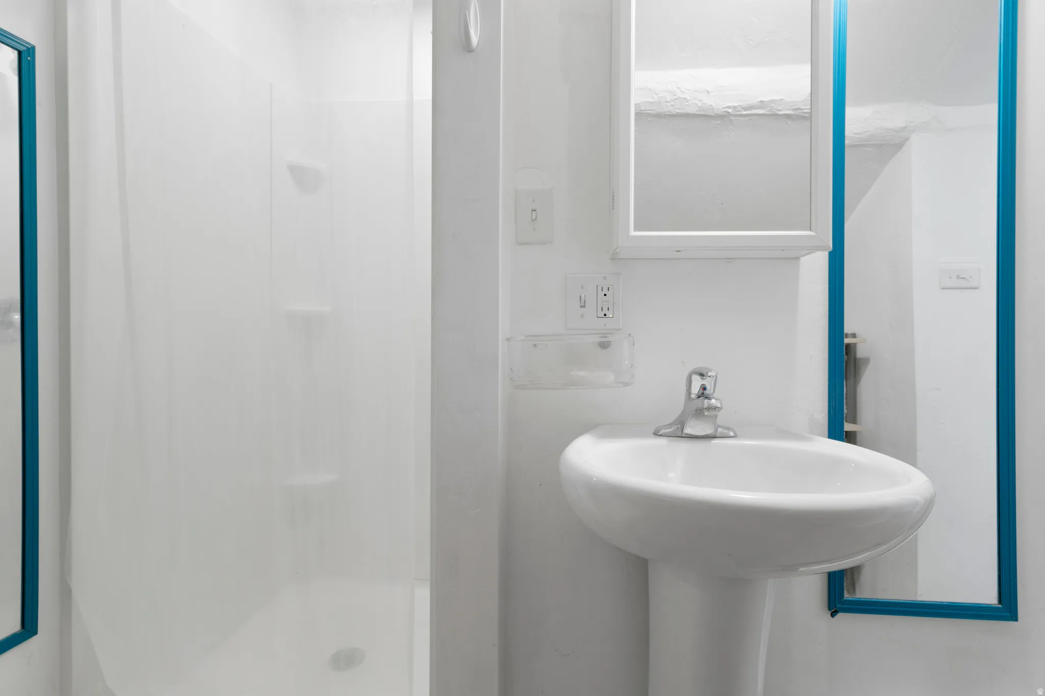 Bathroom with a stall shower and a sink