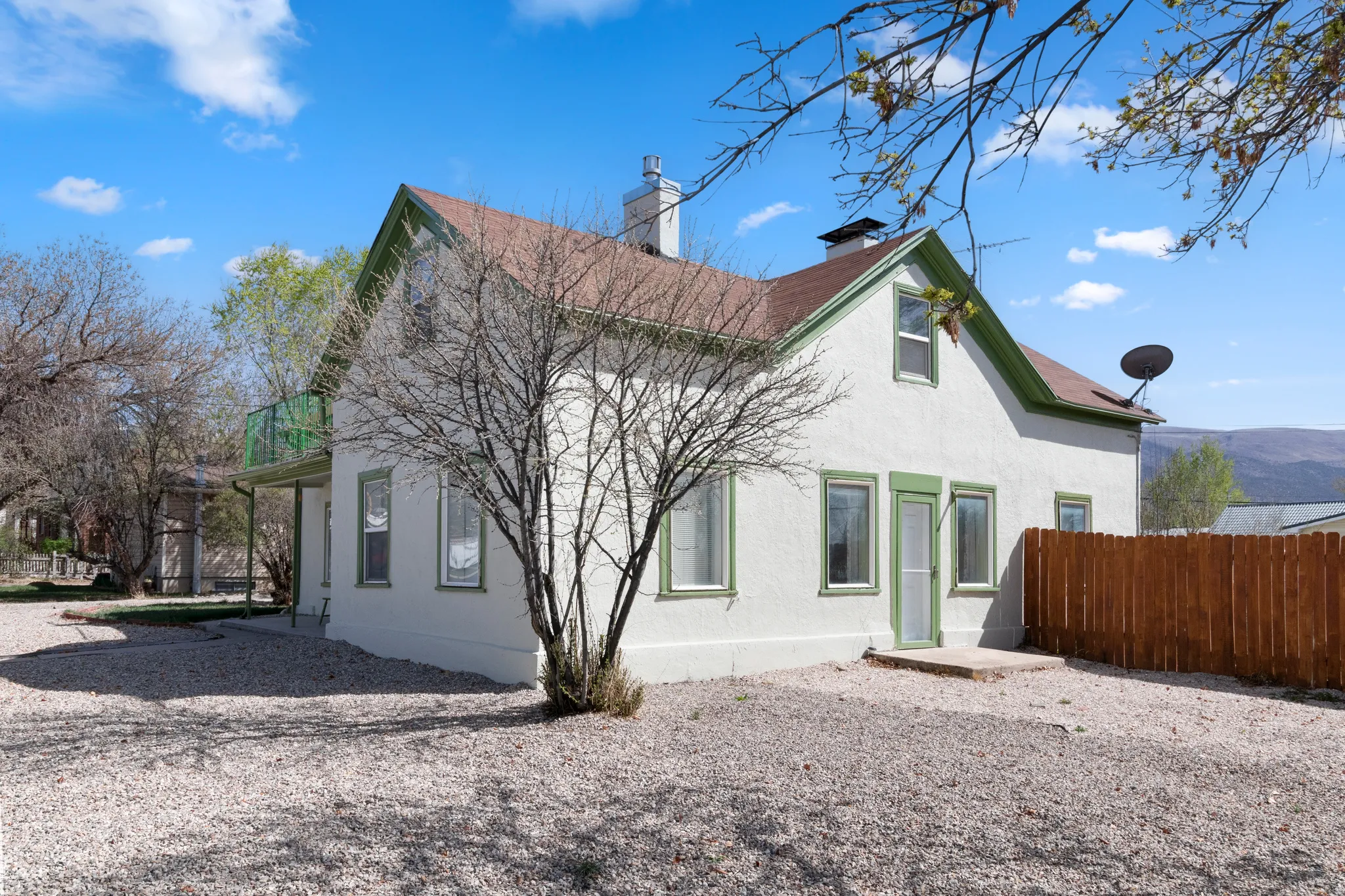 Rear view of property featuring a chimney and stucco siding