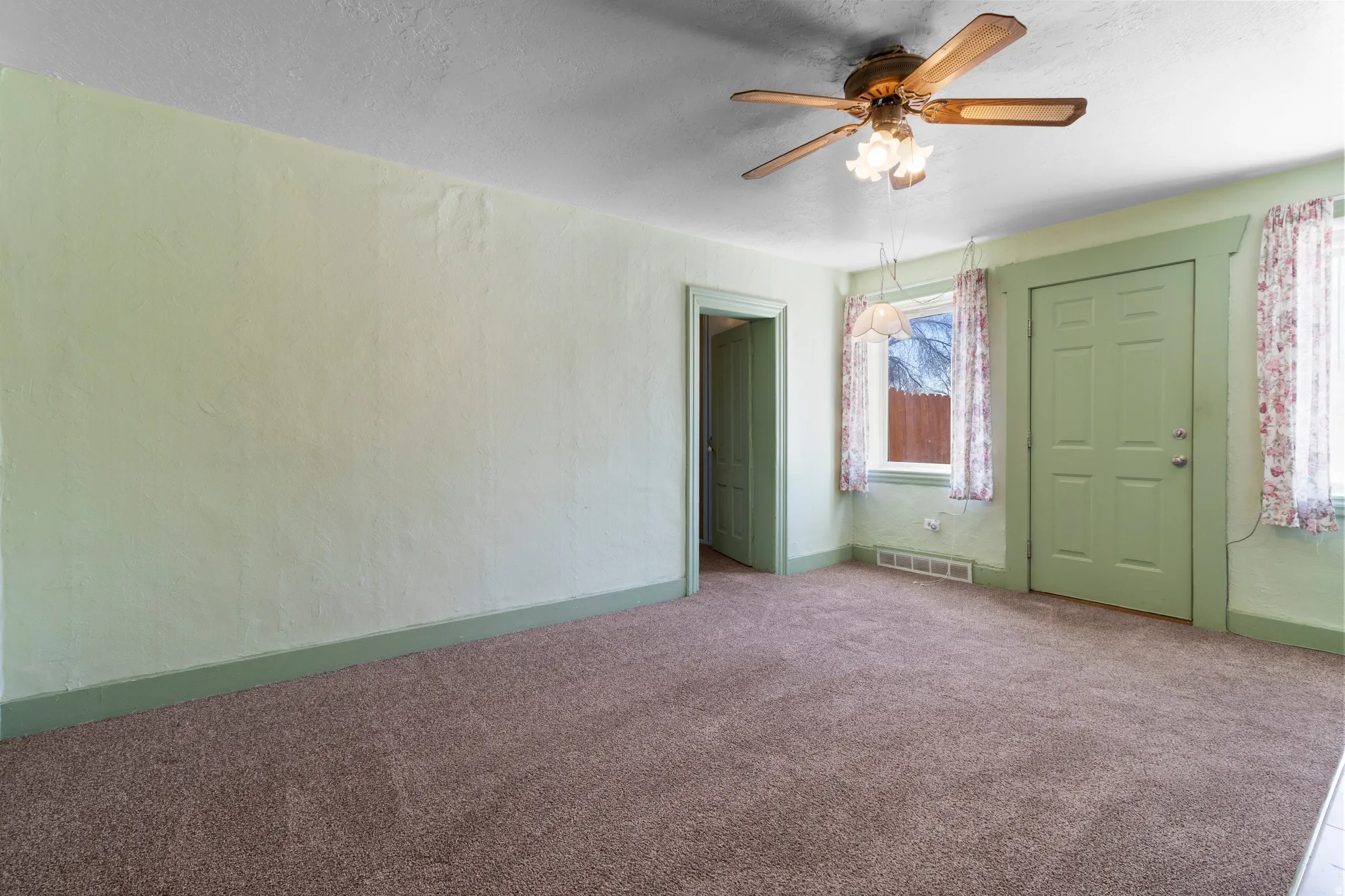Carpeted spare room featuring ceiling fan, a textured ceiling, and a textured wall