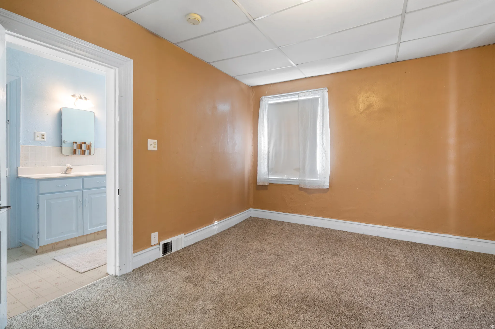 Unfurnished room with a paneled ceiling and light colored carpet
