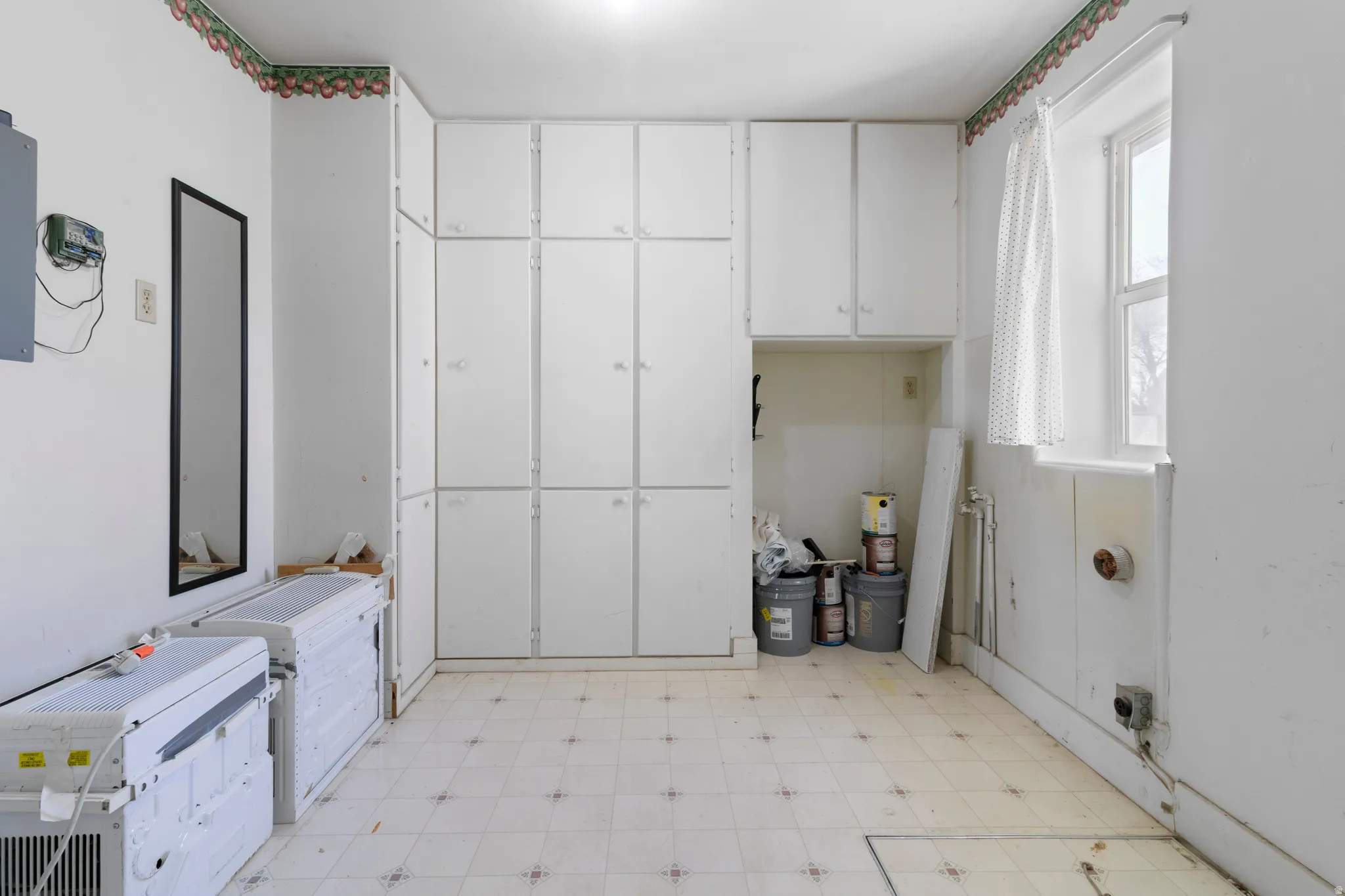 Laundry room featuring light floors and cabinet space