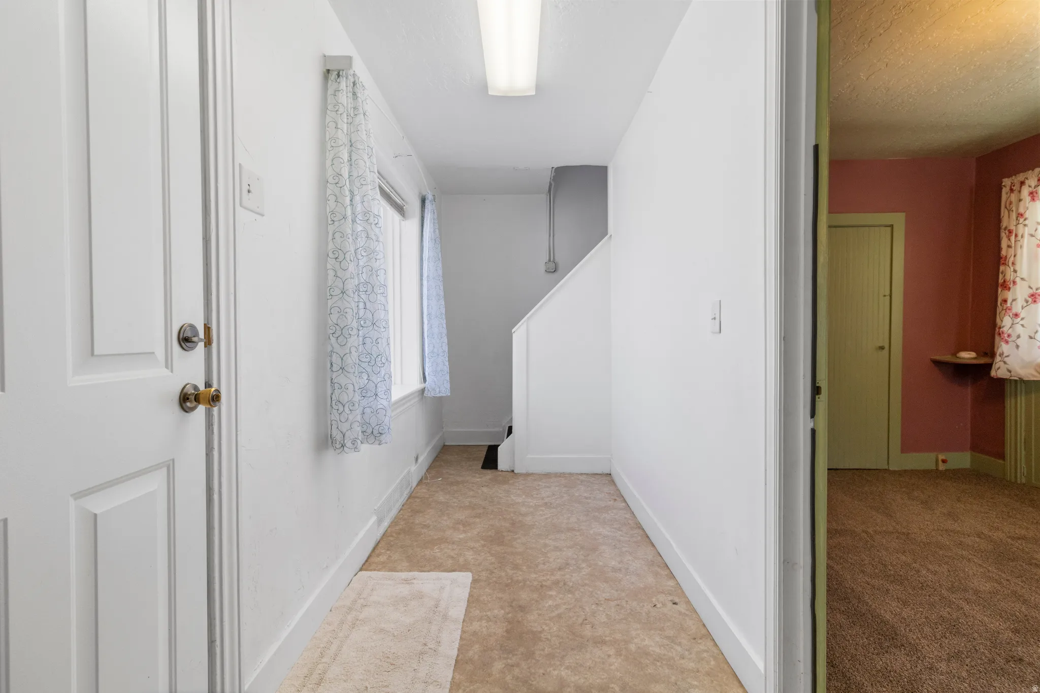 Hall featuring baseboards and a textured ceiling
