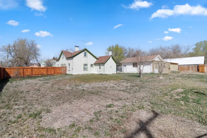 Rear view of property with a fenced backyard, an outbuilding, and a residential view