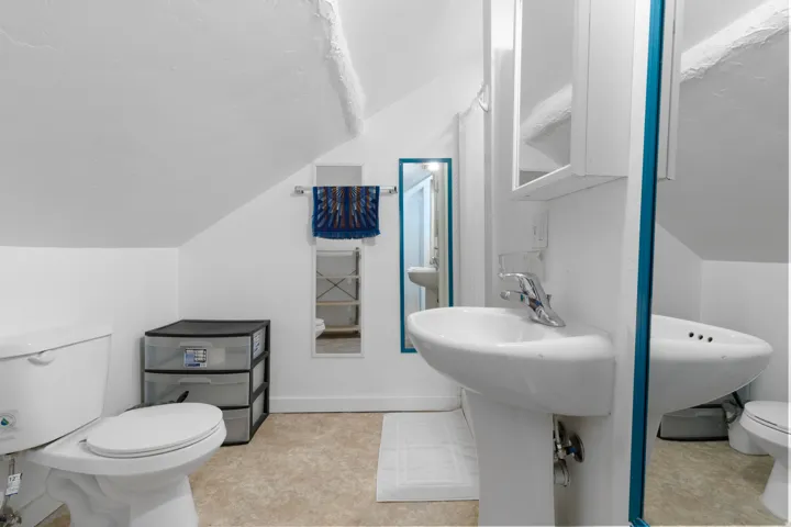 Half bathroom with toilet and lofted ceiling