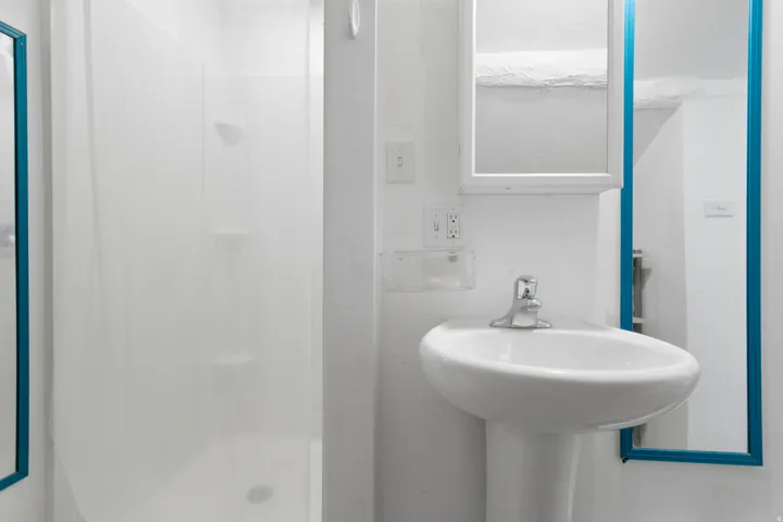 Bathroom with a stall shower and a sink