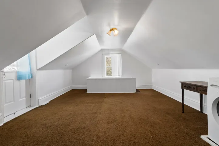 Additional living space with dark carpet and washer / clothes dryer