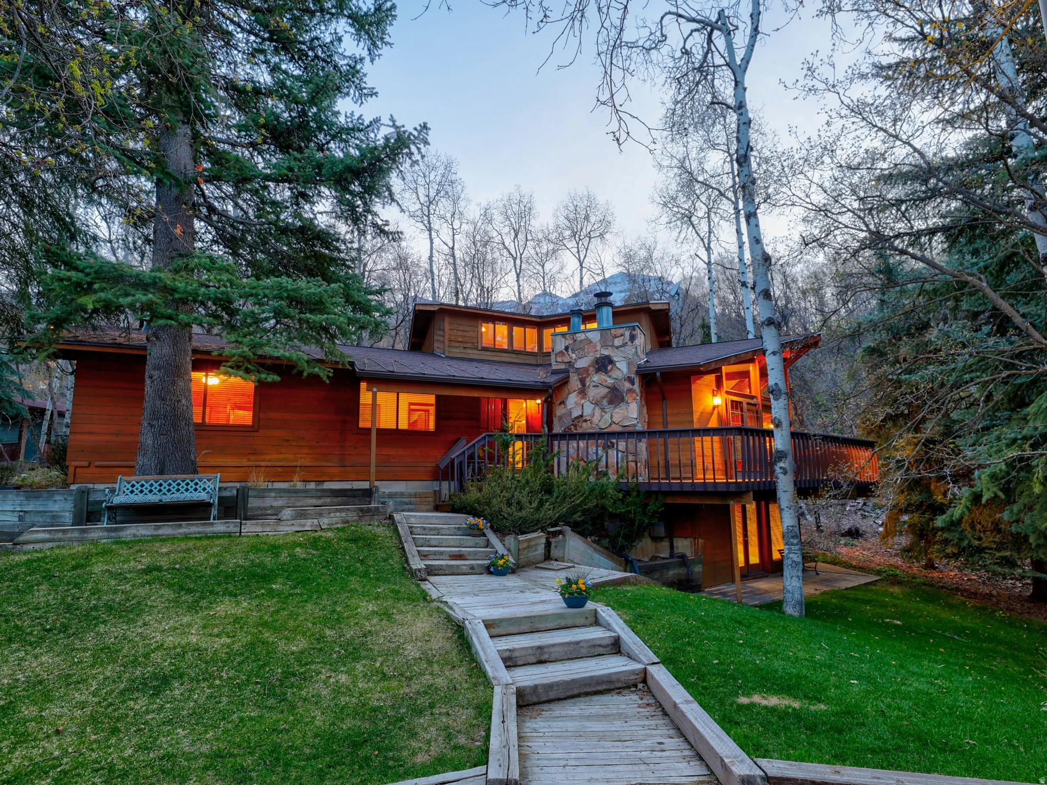 Classic mountain home at dusk with 3 floors, large, beautiful yard, 2 masonry stone fireplaces, 5 bedrooms, 4 baths, large, wrap-around deck. Perfect location!