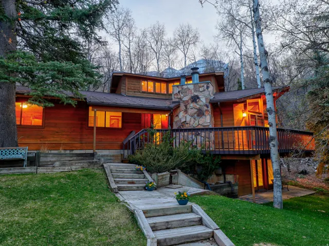 Classic mountain home at dusk with 3 floors, large, beautiful yard, 2 masonry stone fireplaces, 5 bedrooms, 4 baths, large, wrap-around deck. Perfect location!