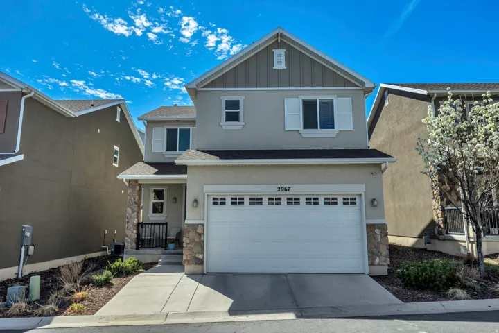 Craftsman house featuring stone siding, board and batten siding, a garage, and concrete driveway