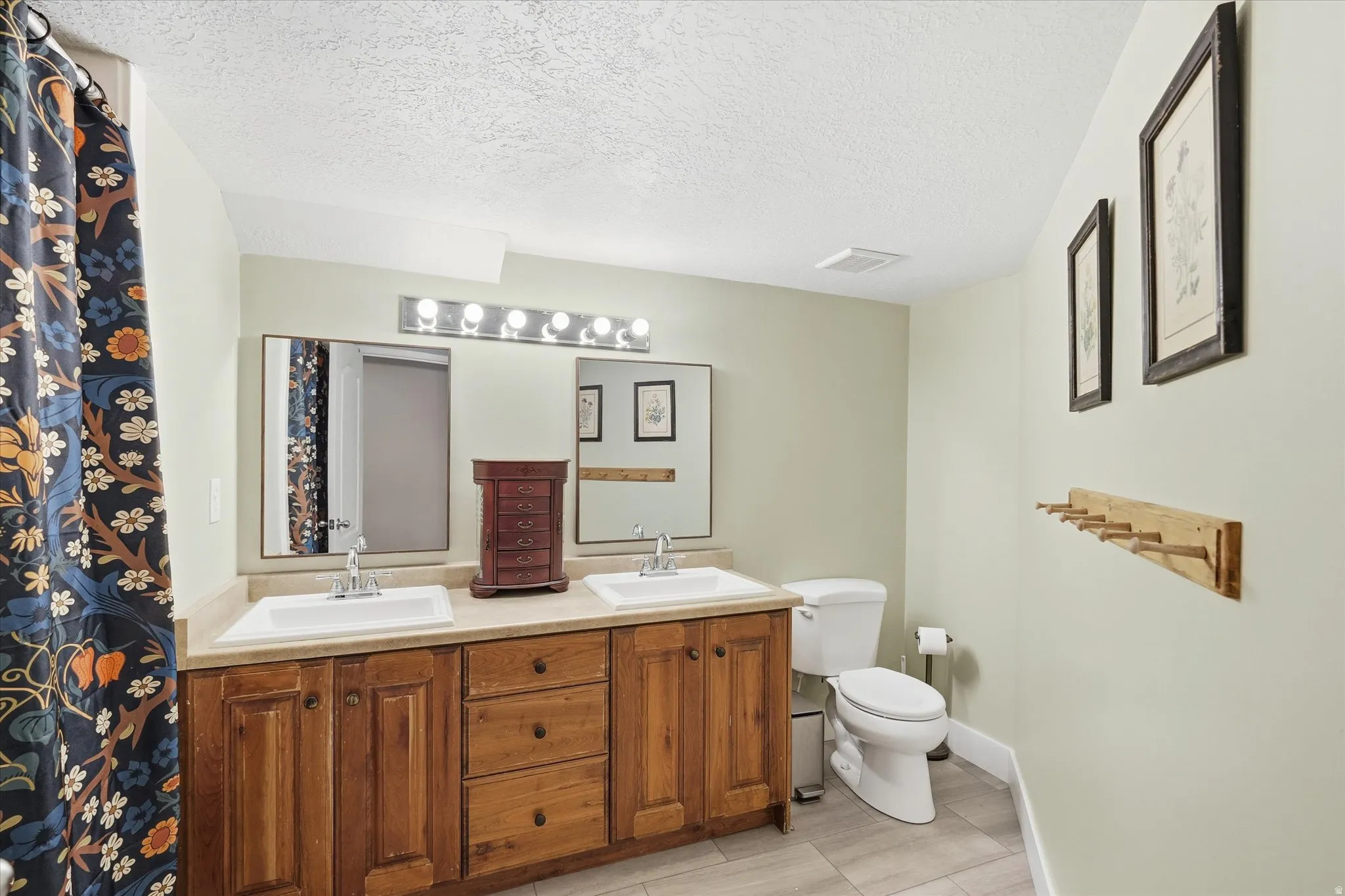 Bathroom featuring double vanity and a textured ceiling