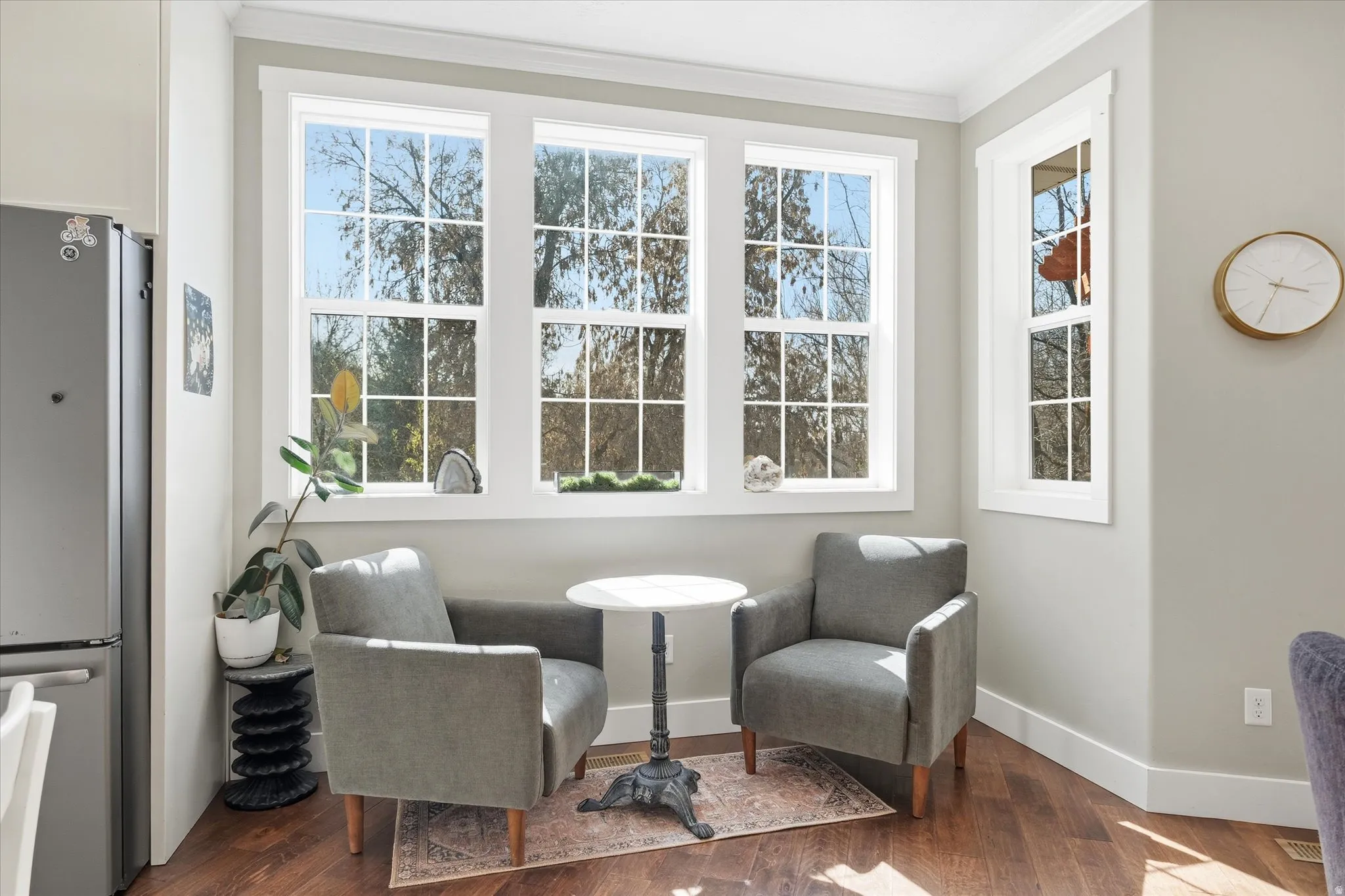 Living area featuring dark wood finished floors and crown molding