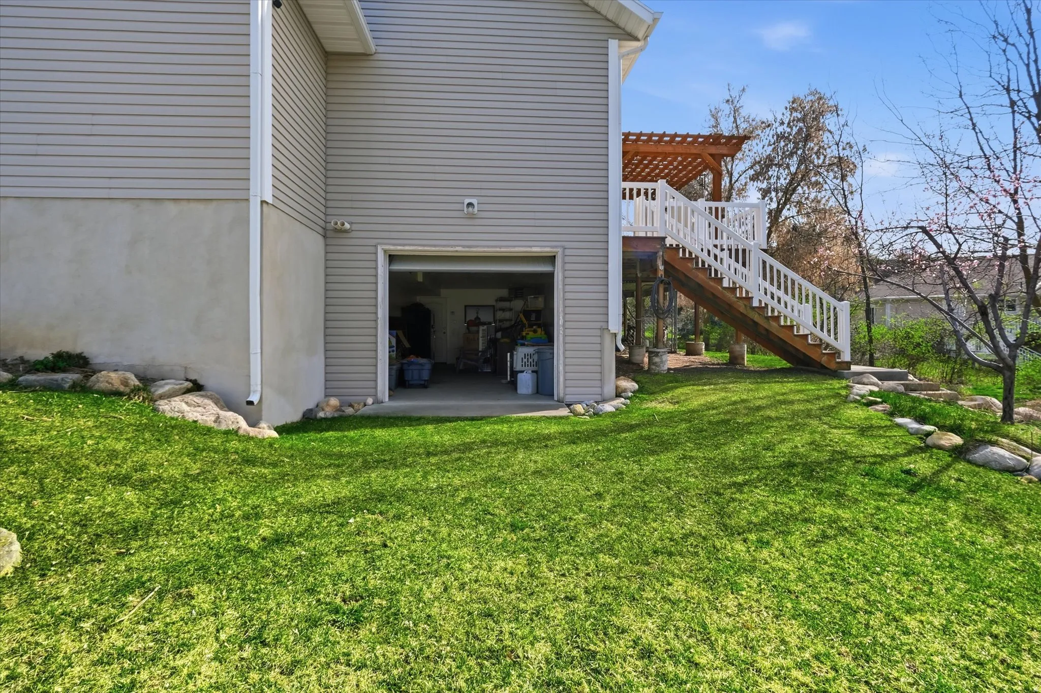 Rear view of property with a garage, a patio, a pergola, and a yard