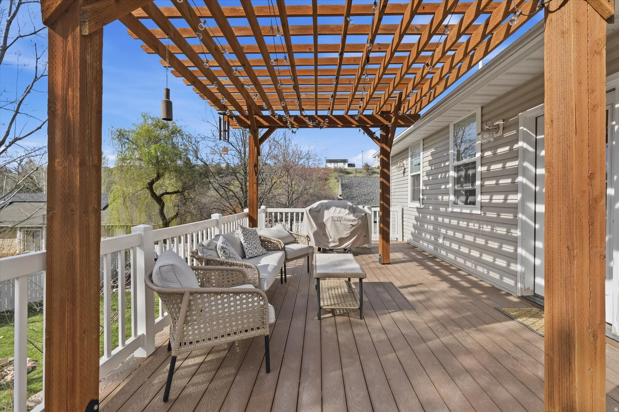 Wooden terrace with an outdoor lounge area and a pergola