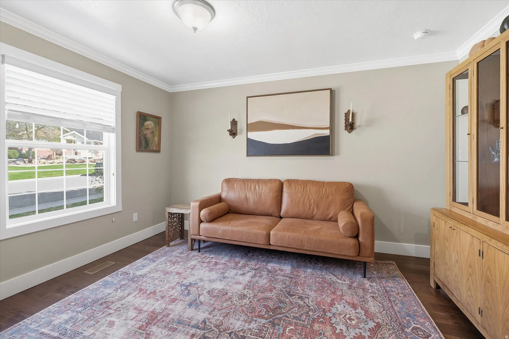 Living area featuring crown molding and dark wood-type flooring