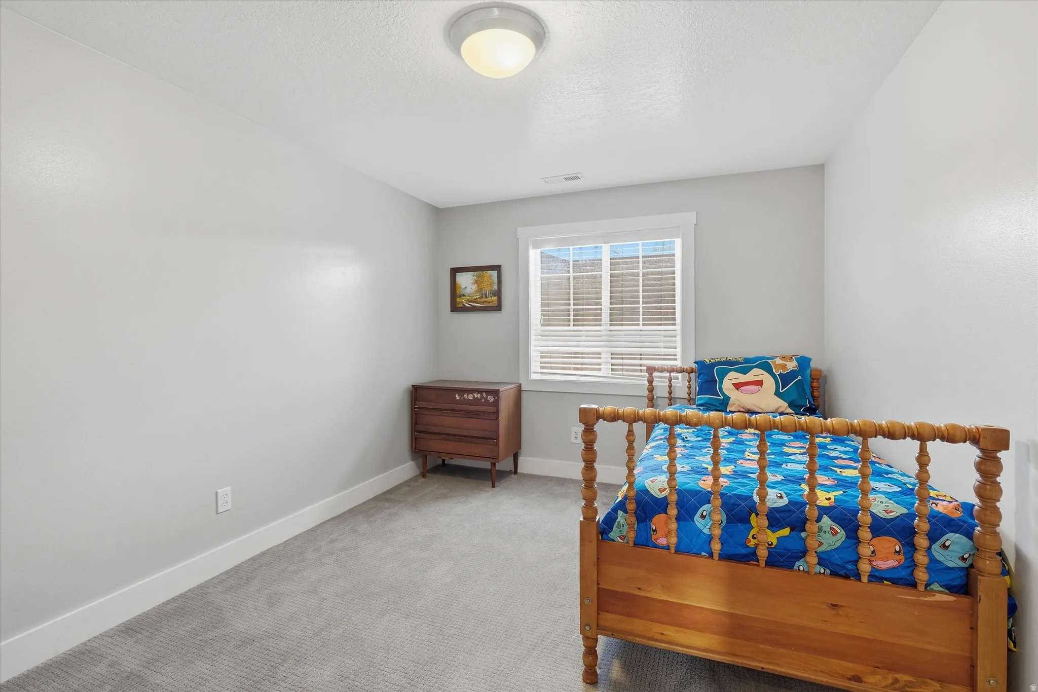 Bedroom featuring light carpet and a textured ceiling
