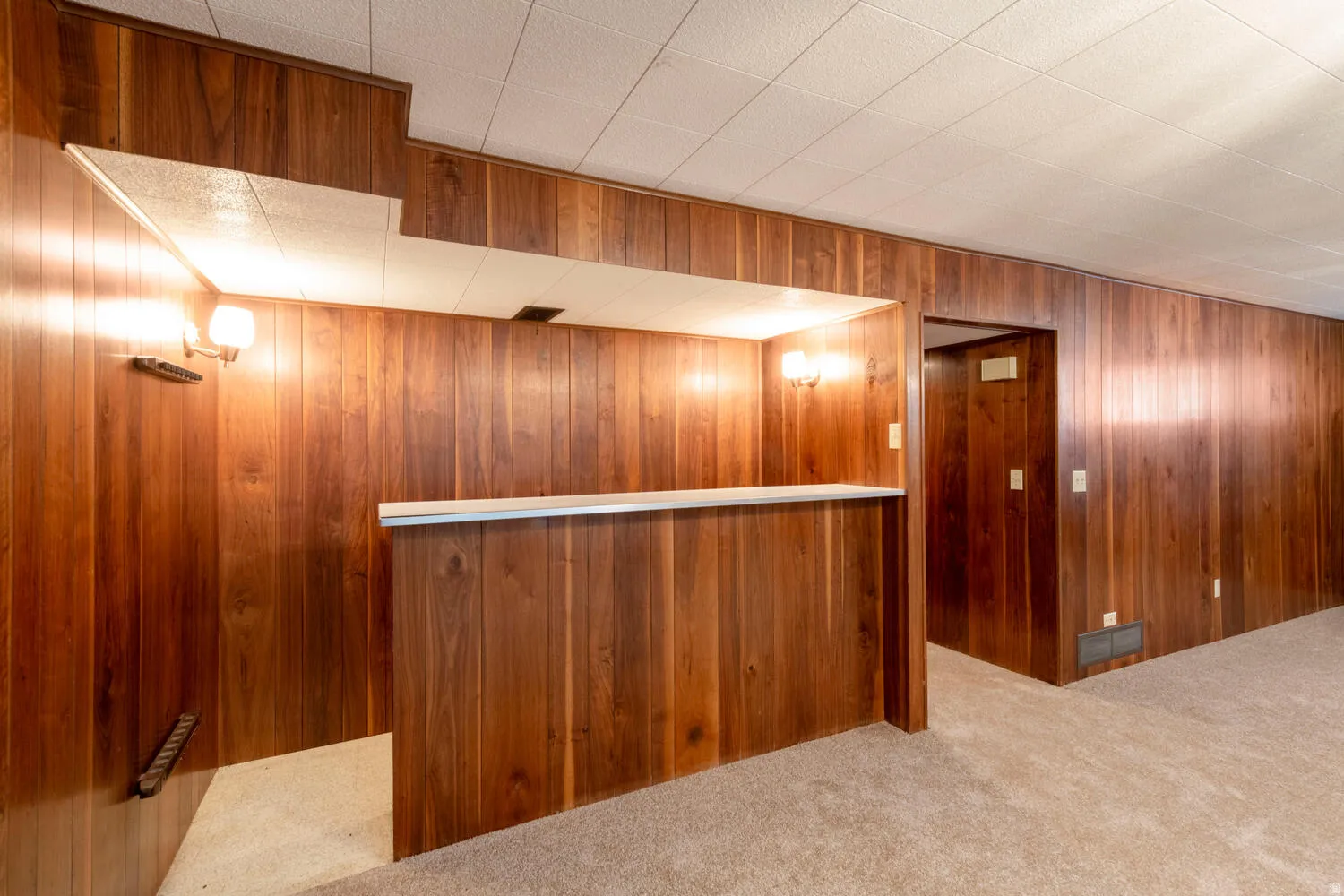 Bar area with carpet flooring and wooden walls