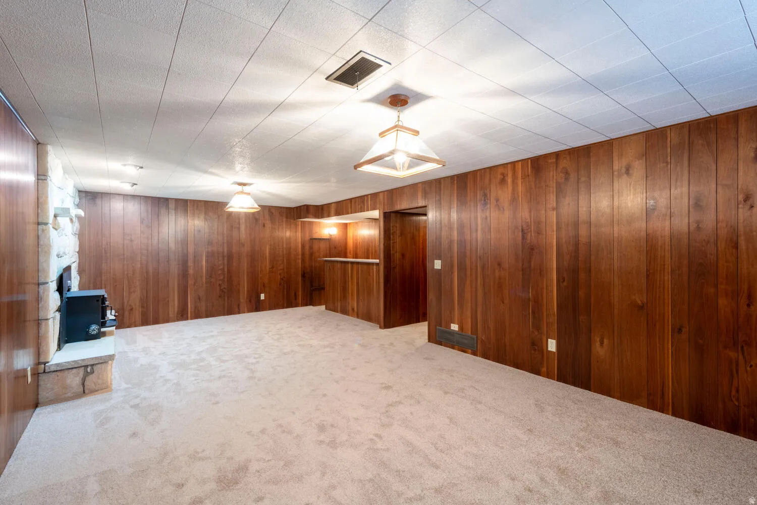 Finished basement with carpet floors and wood walls