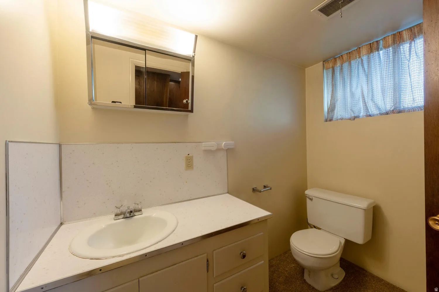 Half bath featuring vanity and backsplash