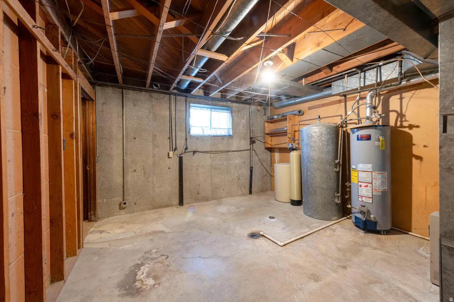 Basement featuring water heater and a water softener