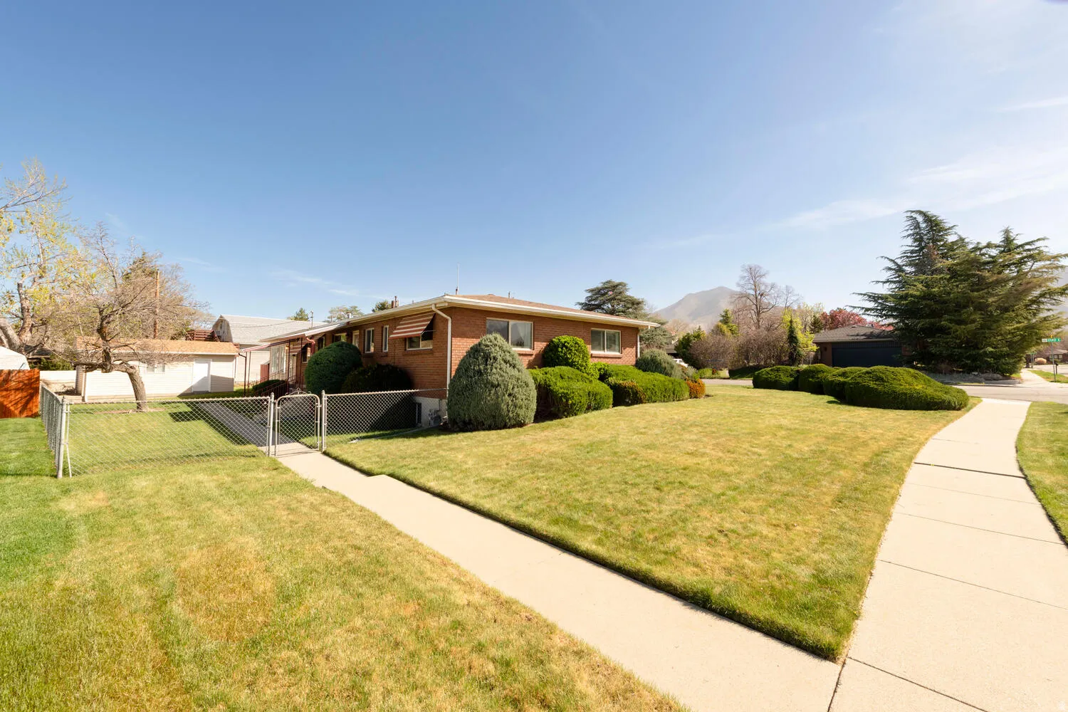 View of property exterior with a gate, a fenced front yard, and brick siding