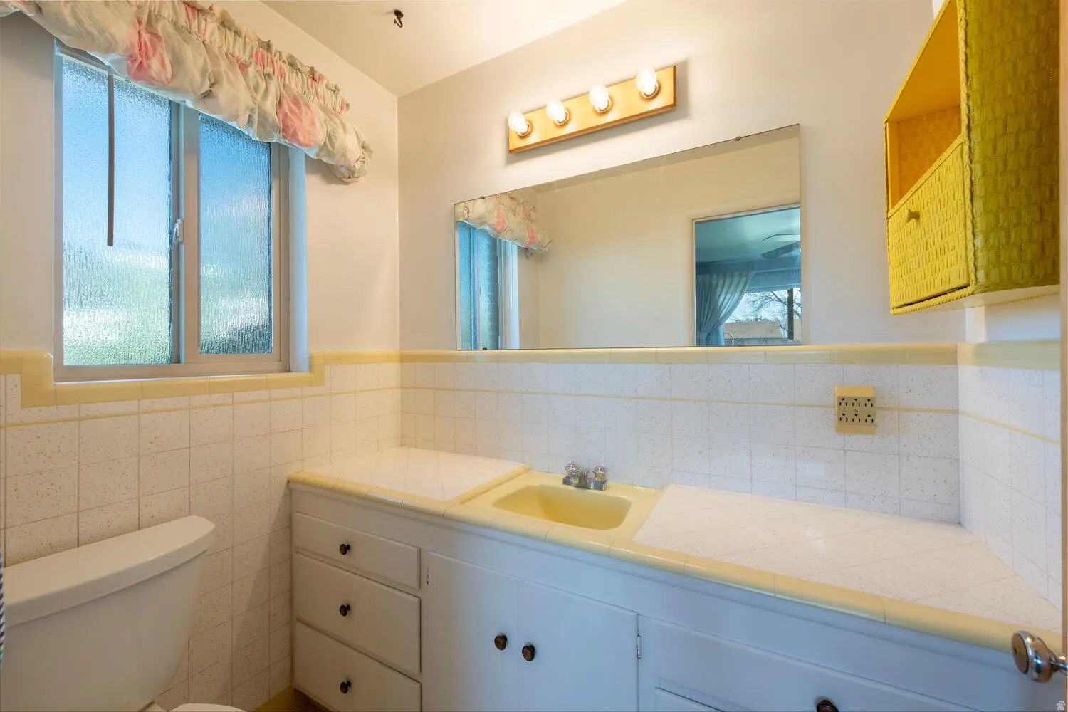 Bathroom with vanity, wainscoting, and tile walls