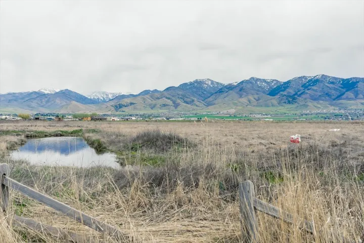 View of mountain background featuring a large body of water and rural landscape