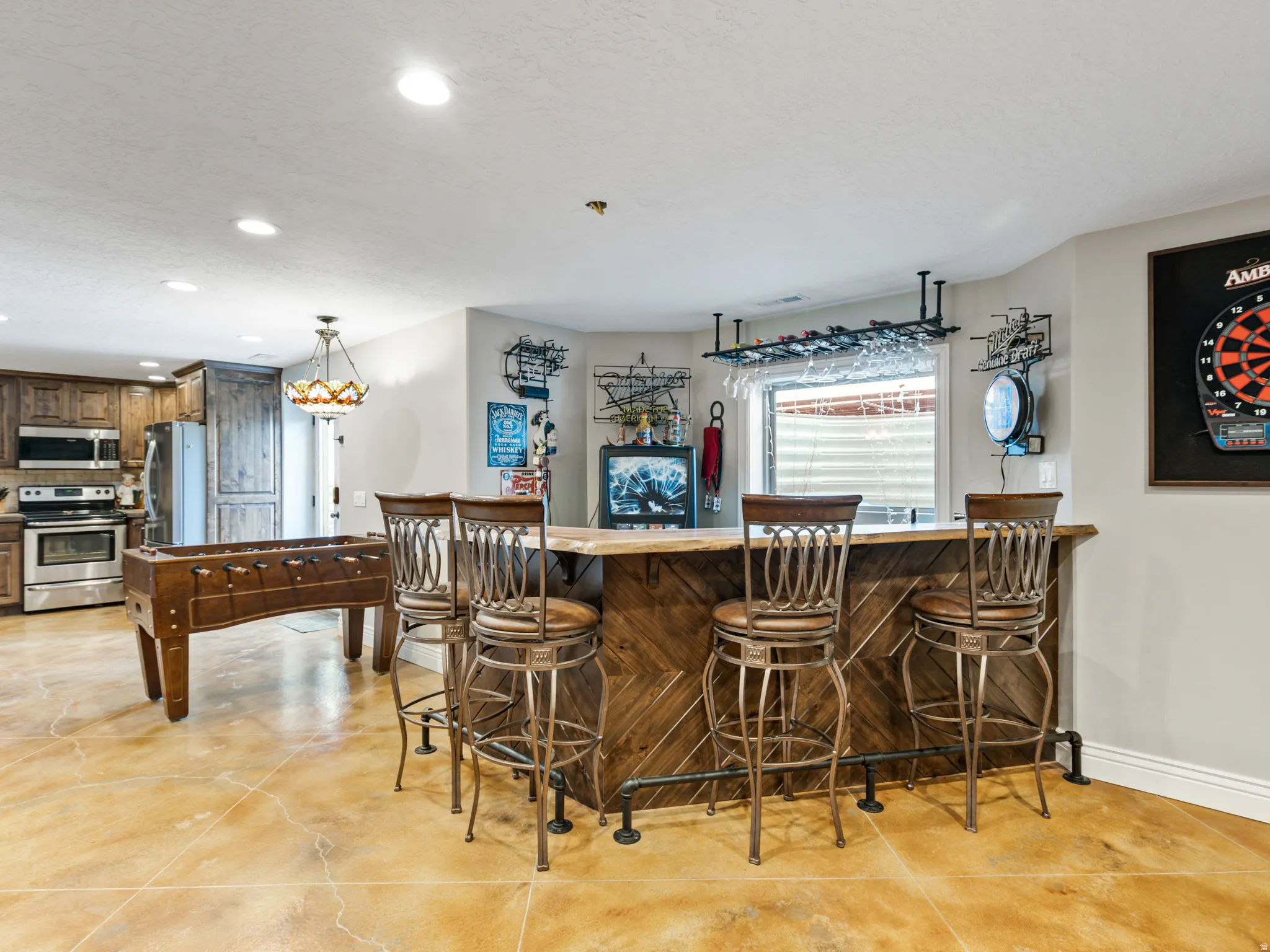 Indoor dry bar with stainless steel appliances, recessed lighting, a textured ceiling, and dark wood finish cabinetry