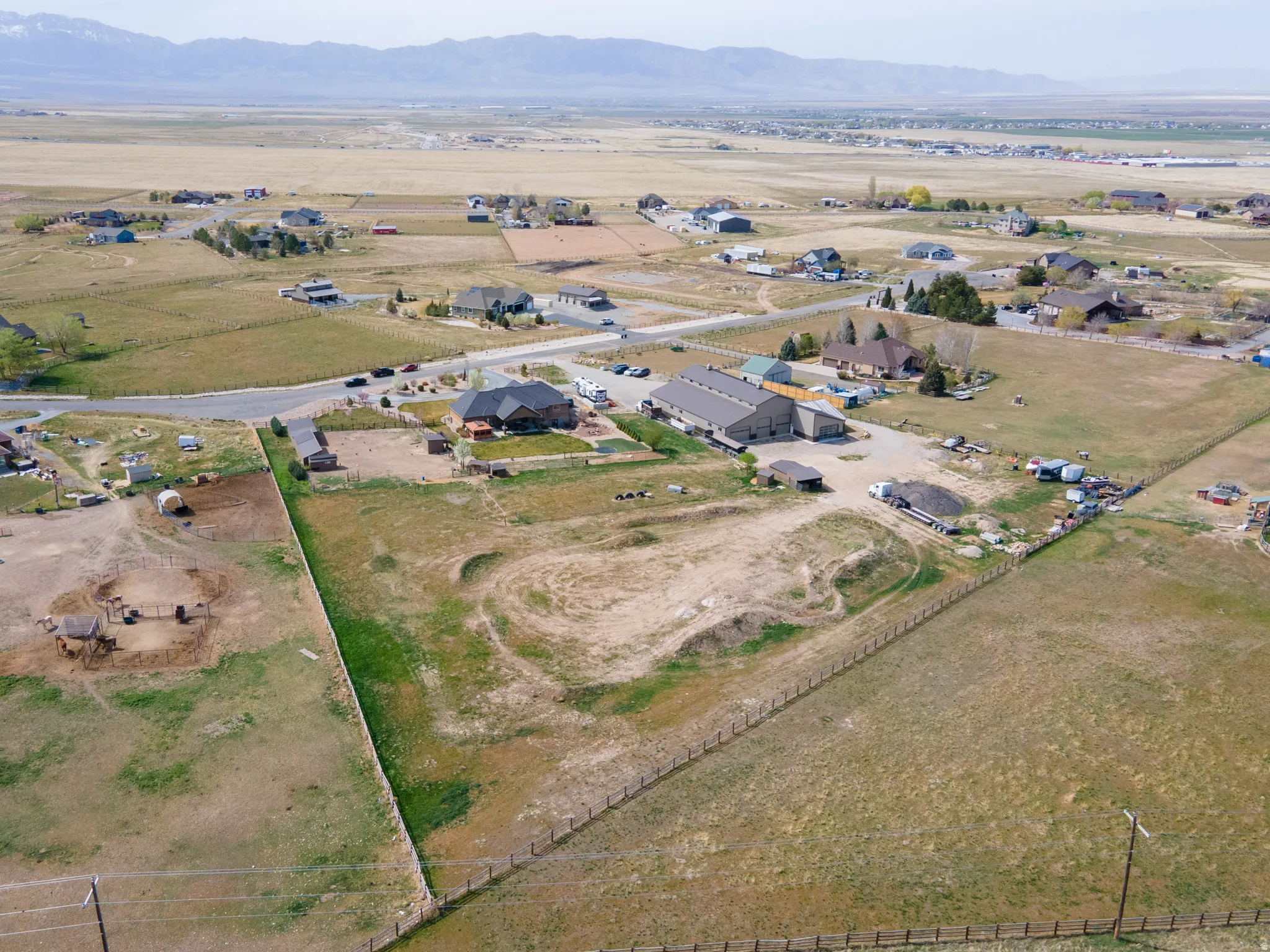 Aerial view of property and surrounding area featuring rural landscape and nearby suburban area