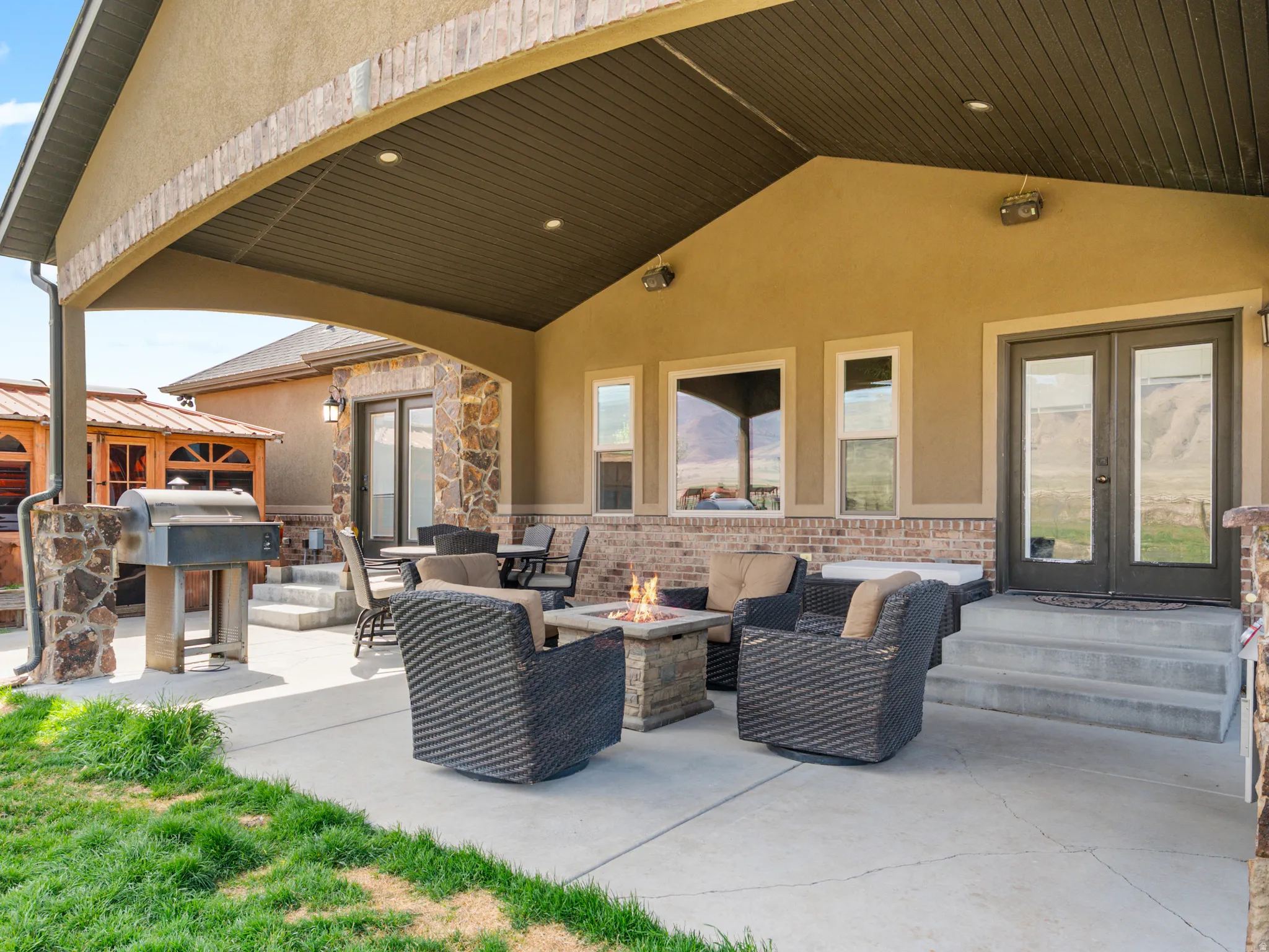 View of patio with french doors, an outdoor fire pit, and grilling area