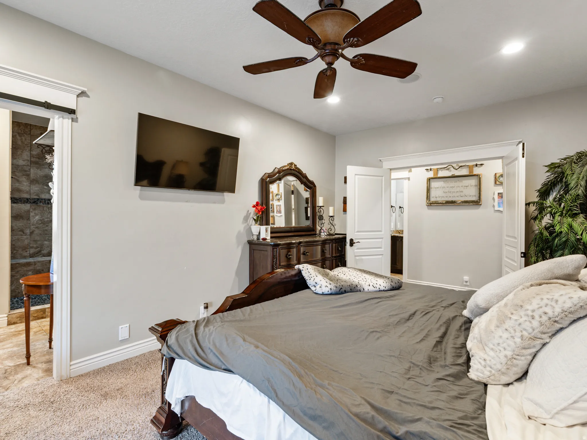 Bedroom featuring ensuite bath, light carpet, a ceiling fan, and recessed lighting