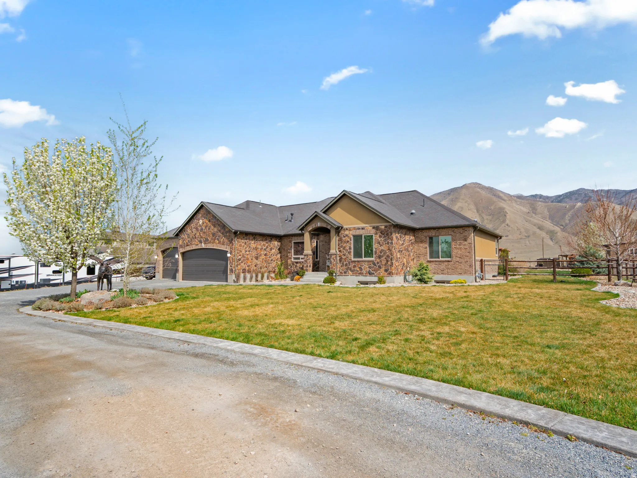 View of front of home featuring brick siding, an attached garage, driveway, and a mountain view