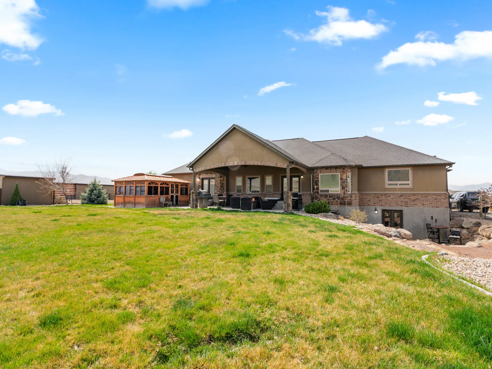 Rear view of property featuring a patio, a yard, and stucco siding