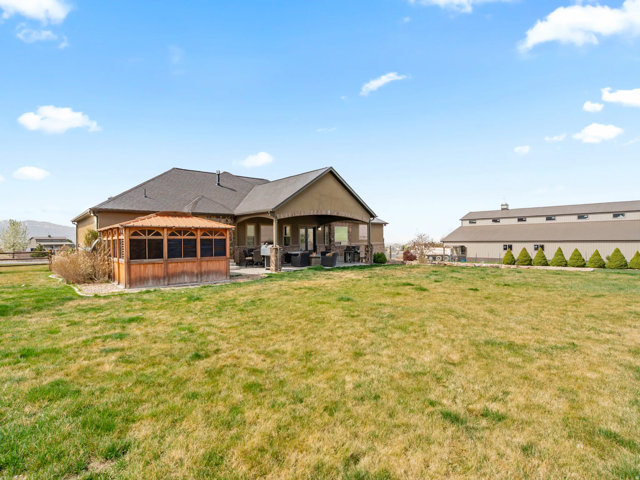 Rear view of house featuring a patio, a lawn, and a sunroom