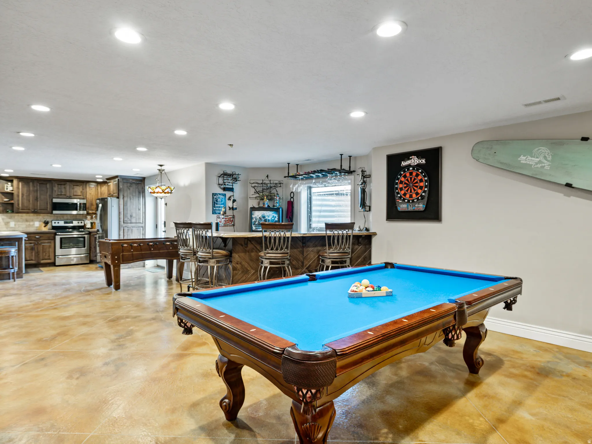 Rec room featuring billiards table, finished concrete flooring, recessed lighting, and bar