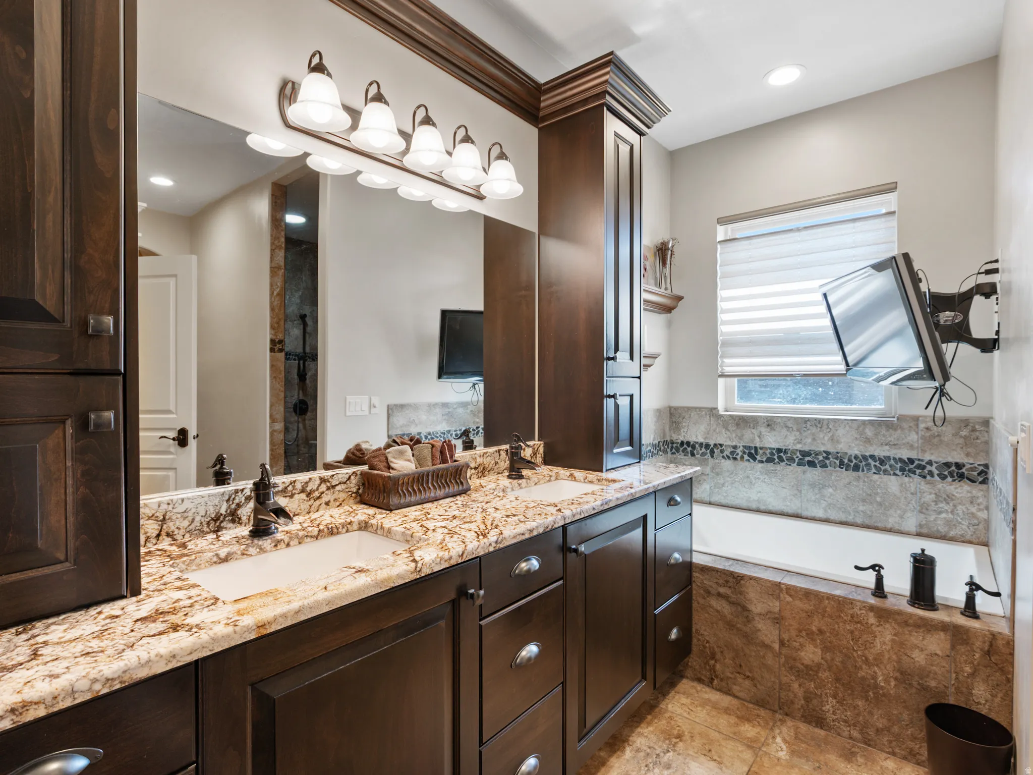 Full bathroom featuring double vanity, a stall shower, a bath, and recessed lighting