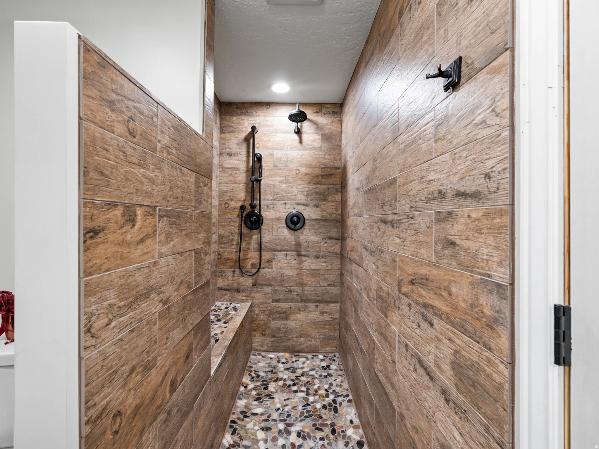 Full bathroom with tiled shower and a textured ceiling