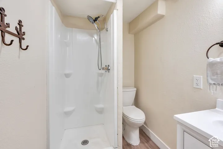 Bathroom featuring a white shower stall with built-in shelving and a chrome shower head