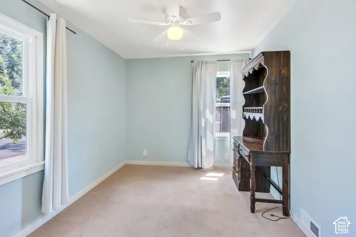 Room featuring light blue walls, neutral carpet flooring, and white trim